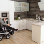 A man on a wheelchair using a microwave