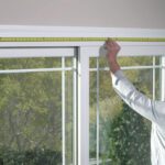 A man measuring the size of a window